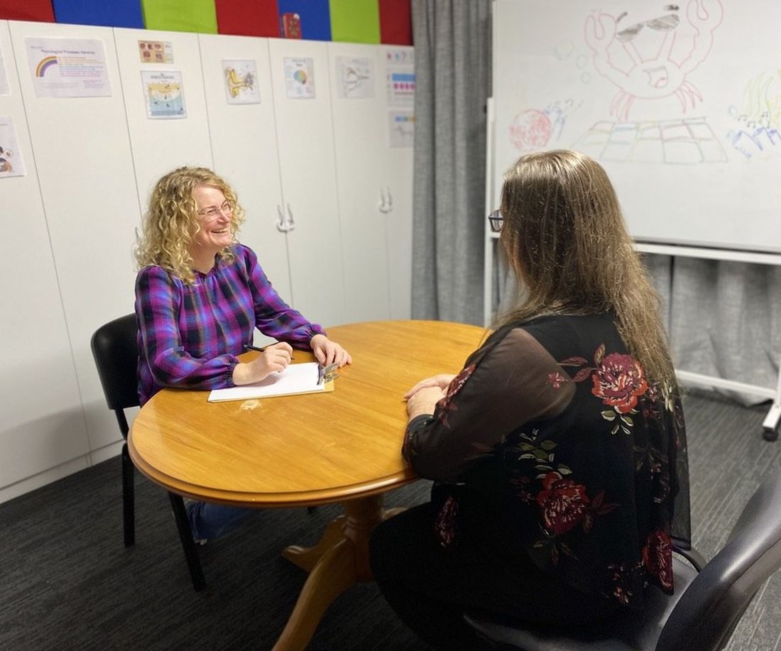 Sarah in conversation with an adult client during a therapy session